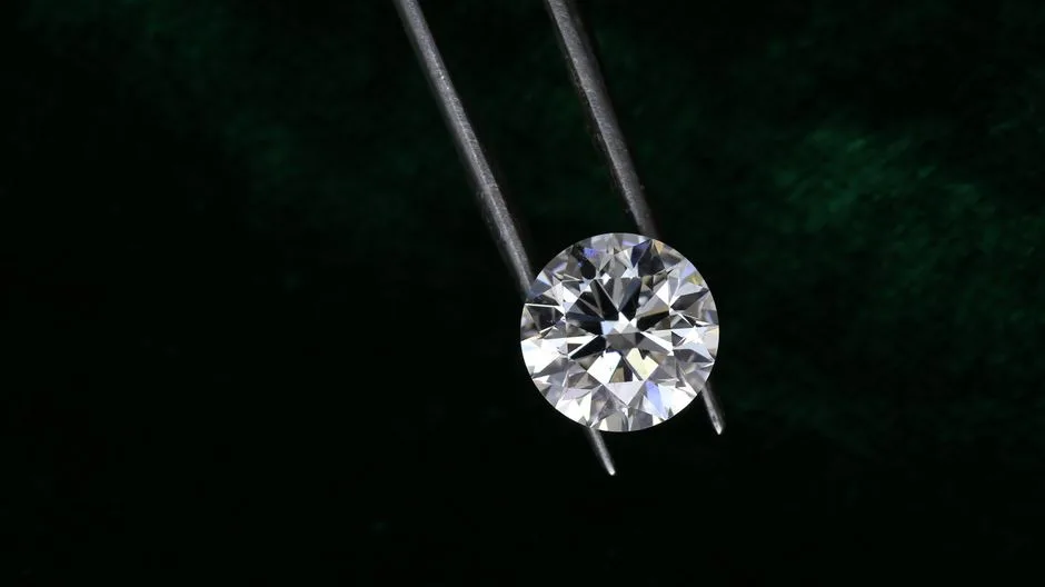 Loose lab grown diamonds held in tweezers for inspection