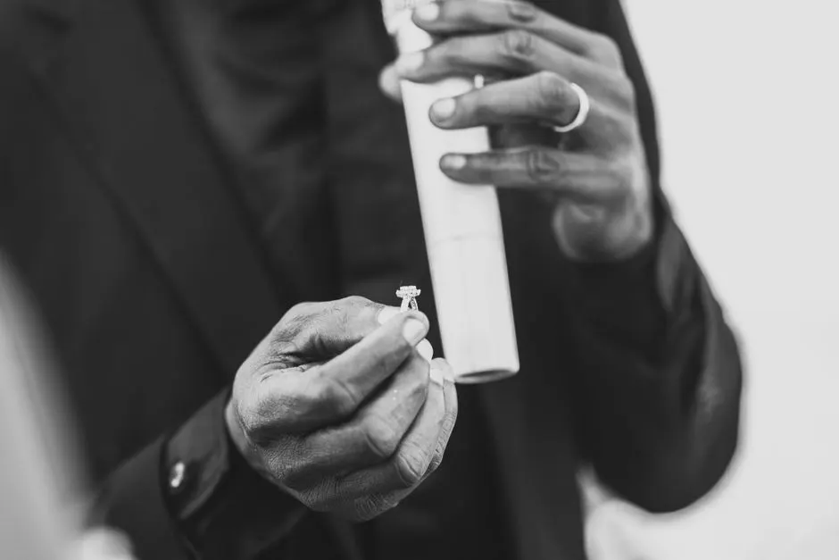 A ring being handed across a counter with its grading report